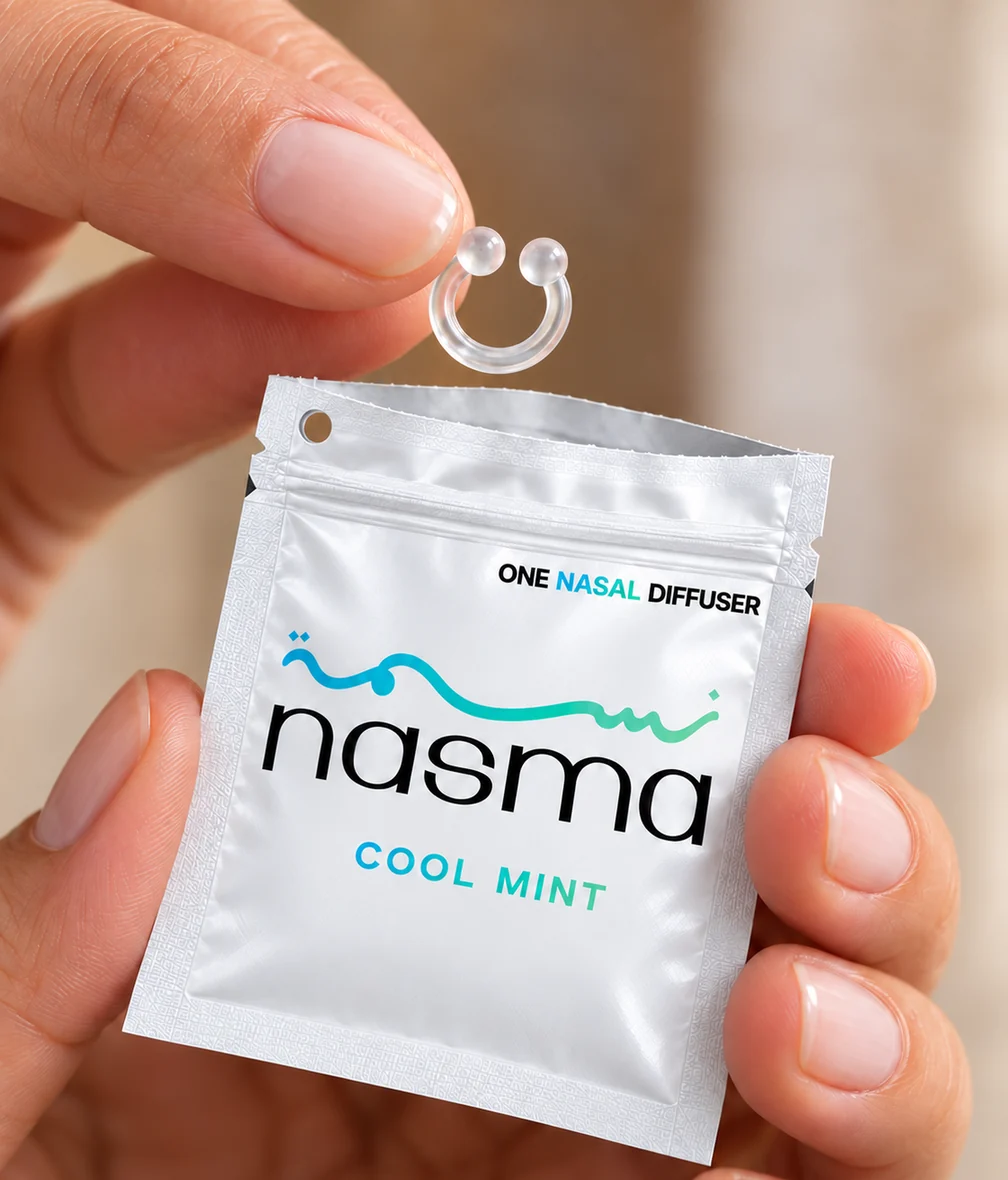 Fingers taking a clear NASMA ring out of a Cool Mint pouch